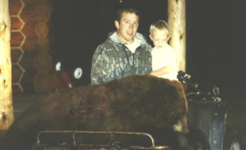 Rob Horton with his son Garrett with a big brown color phase black bear he shot in 1997.